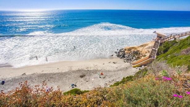 A beach with a wooden staircase leading down to the shore, a clear view of the ocean, and a sandy beach area. - 10% OFF last minute stays - Oceanfront 1 bedroom, Pool, Spa, Beach Access (Solana Beach)