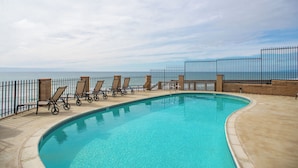 A swimming pool with lounge chairs and a view of the ocean. - 10% OFF last minute stays - Oceanfront 1 bedroom, Pool, Spa, Beach Access (Solana Beach)