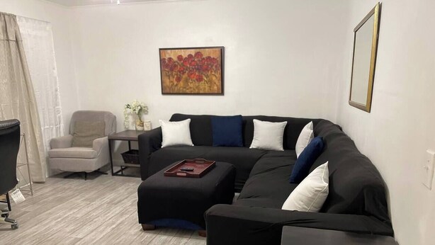 A modern living room with a sectional sofa, a small table, and a chair. - Peaceful Retreat Near the Waterfront (Elizabeth City)