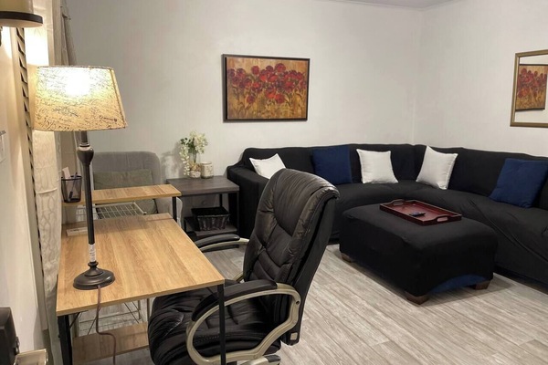 Living room with large sectional and smart TV and desk area