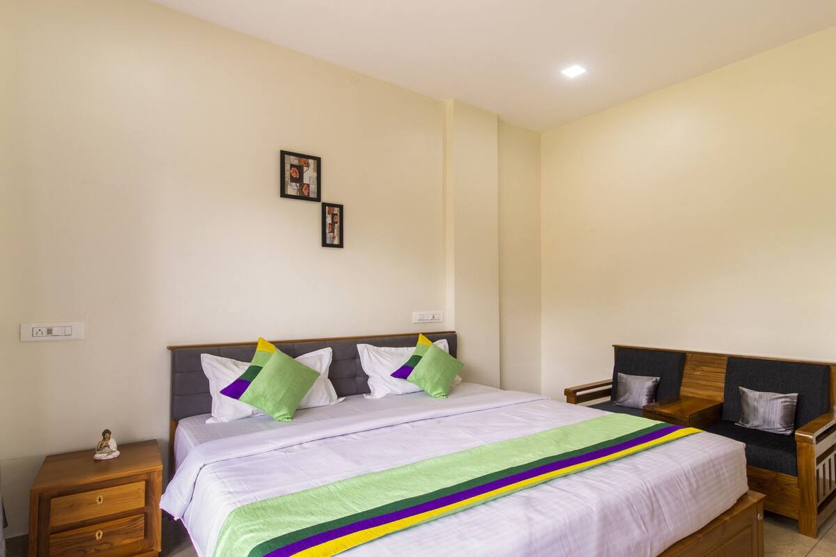 Une chambre à coucher comprenant un lit, des tables de chevet, une commode et une coiffeuse.