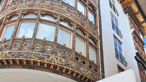 Un edificio con un letrero que dice "KAACHI GRAND" y una entrada decorativa con un portón con diseño.