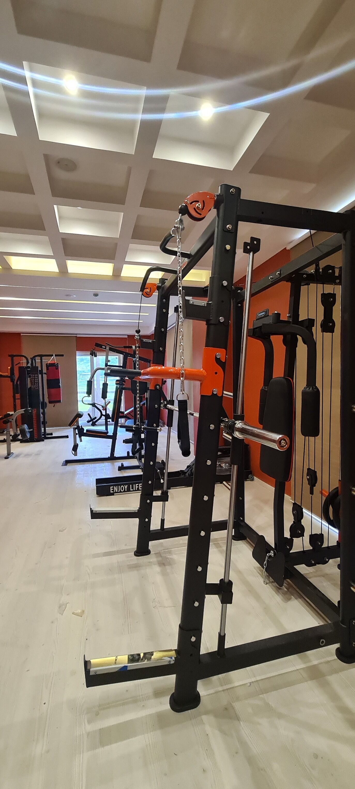 A gym with various exercise equipment, including a squat rack and weight benches.