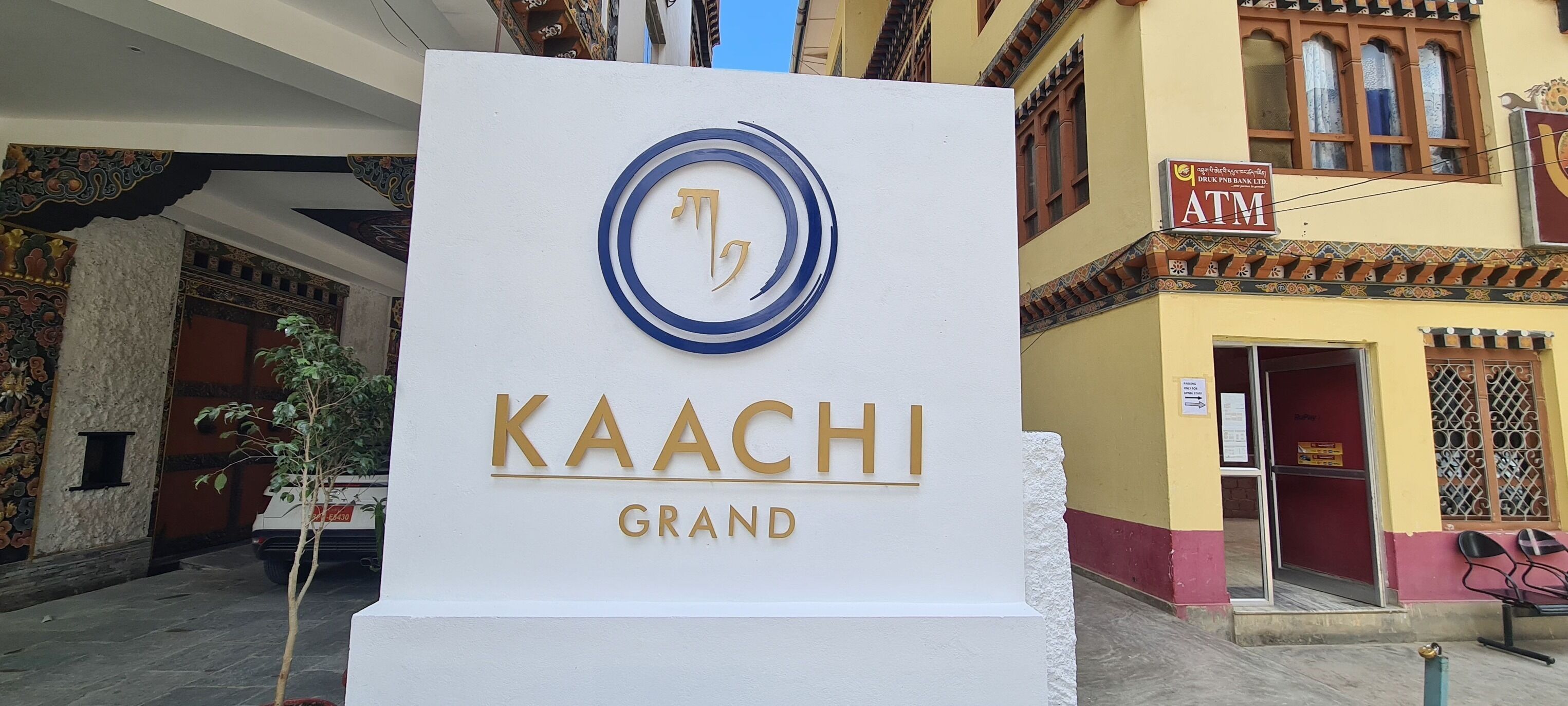 A hotel sign with the name "KAACHI GRAND" and a logo.