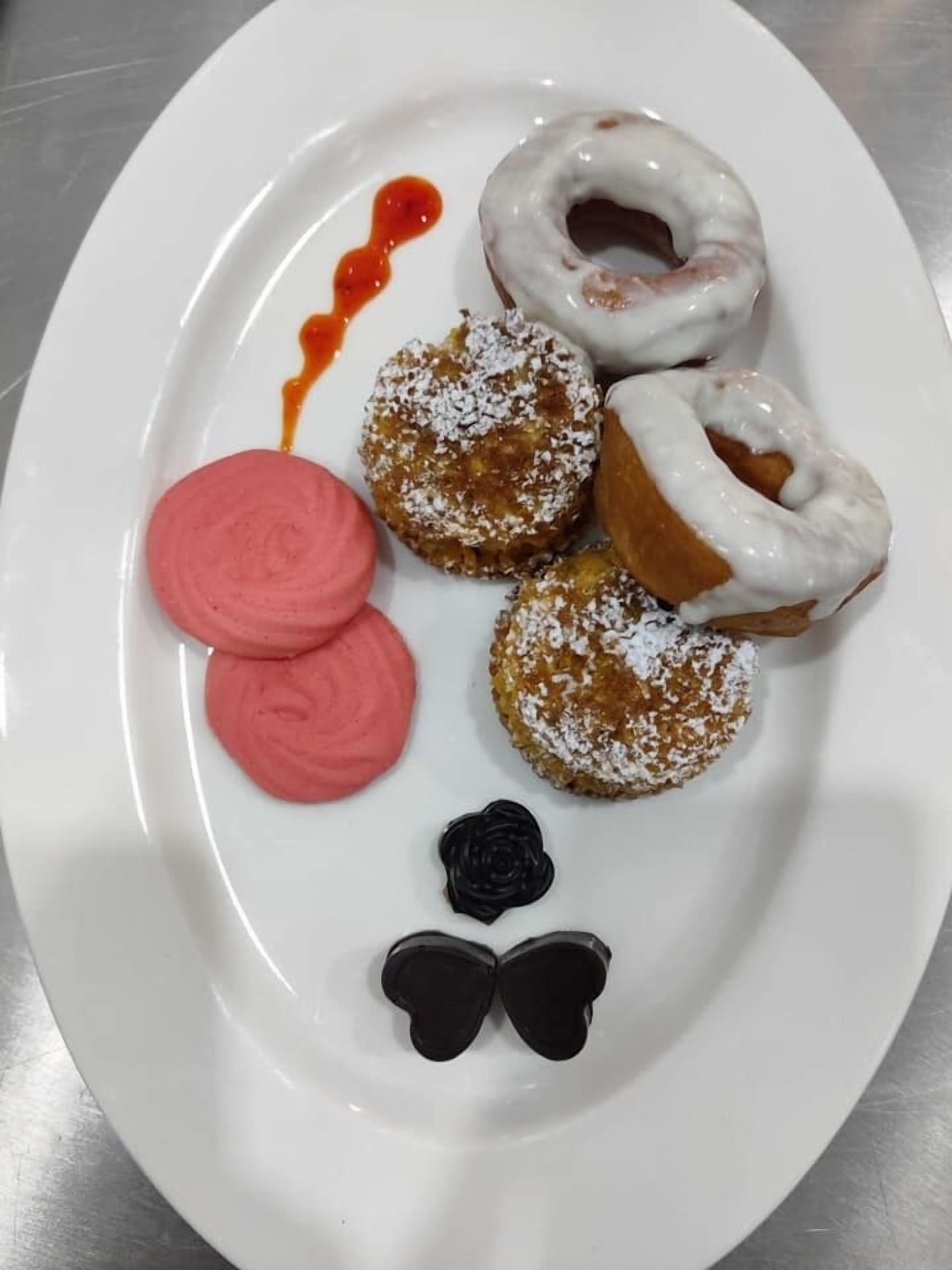 A white plate with various pastries and a small chocolate decoration.