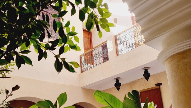 A courtyard with a fountain, potted plants, and outdoor seating. - Riad La Bigarade (Marrakech)