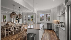 A modern kitchen with white cabinetry, stainless steel appliances, and a central island. - Seabrook Main House Plus Guest House | Hot Tub Spa | 16+ Guests, Dog Friendly, T (Pacific Beach)