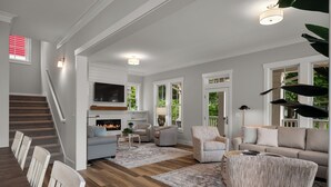 A spacious living room with a fireplace, comfortable seating, and a staircase leading to an upper level. - Seabrook Main House Plus Guest House | Hot Tub Spa | 16+ Guests, Dog Friendly, T (Pacific Beach)