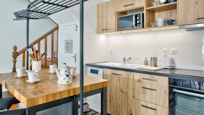 A modern kitchen with wooden cabinets, a built-in microwave, and a dishwasher. - Near the port of Guilvinec, town house for 5 (Le Guilvinec)