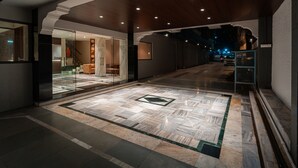 A spacious lobby with a patterned floor, a glass entrance, and a wooden ceiling. - Treebo Kaveri (Nashik)