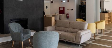 A modern living room with a fireplace, sofas, and chairs.