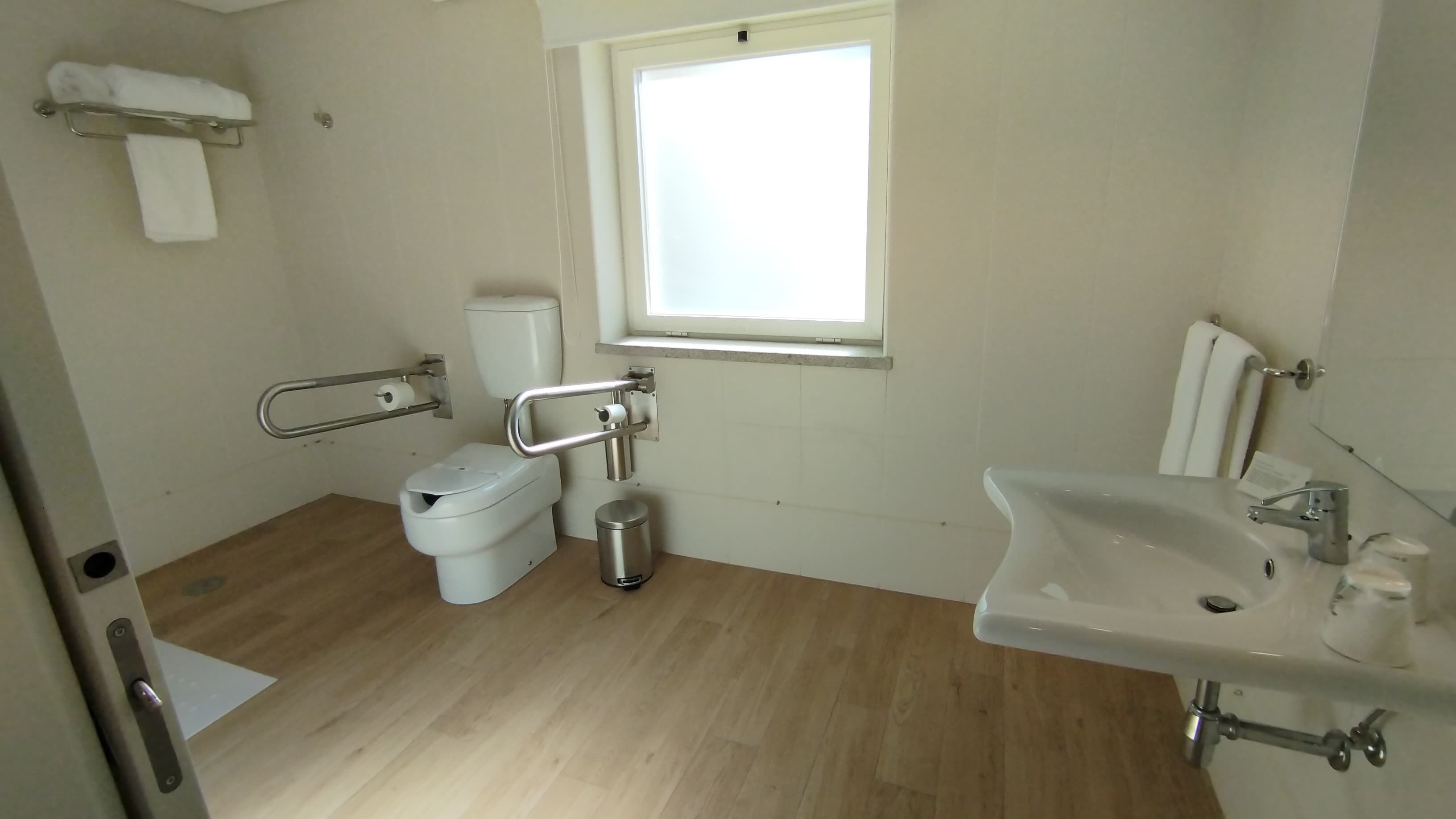 Un baño con inodoro, bidé, lavabo y ventana.