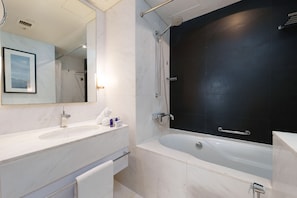Bathtub, hair dryer, towels, toilet paper