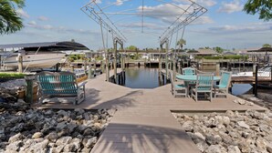 A marina with a covered walkway, boats docked, and outdoor seating. - 🛥️Canal Front with Boat Dock-Awesome Interior-The Sanctuary🛥️ (Fort Myers Beach)