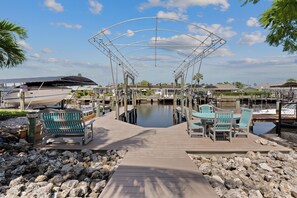 A marina with a covered walkway, boats docked, and outdoor seating. - 🛥️Canal Front with Boat Dock-Awesome Interior-The Sanctuary🛥️ (Fort Myers Beach)