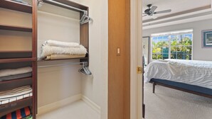 A bedroom with a bed, a closet with hanging clothes, and a window with a view of greenery. - 🛥️Canal Front with Boat Dock-Awesome Interior-The Sanctuary🛥️ (Fort Myers Beach)