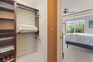 A bedroom with a bed, a closet with hanging clothes, and a window with a view of greenery. - 🛥️Canal Front with Boat Dock-Awesome Interior-The Sanctuary🛥️ (Fort Myers Beach)
