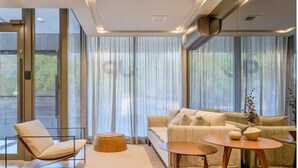A modern living room with a sofa, armchair, ottoman, and coffee table. - JP Redenção, Unique Studio at Downtown Porto Alegre (Farroupilha Porto Alegre)