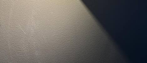 En väggmonterad lampa som skapar en skugga på en vägg med en tydlig yta.