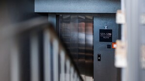 L’intérieur d’un ascenseur avec une plaque indiquant « 501-509 PLUTO ».