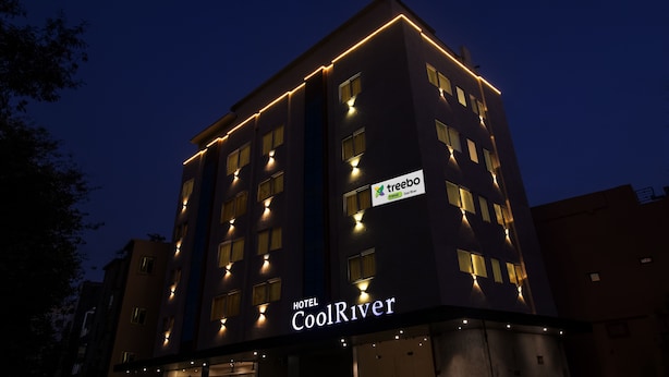 A hotel building with illuminated windows and a sign that reads "HOTEL CoolRiver". - Treebo Cool River (Visakhapatnam)