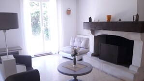 A modern living room with a fireplace, a sofa, a coffee table, and a lamp. - Gite en Provence capacité 6 personnes (Entressen)