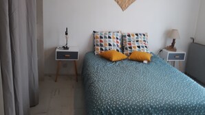 A bedroom with a bed, two bedside tables, a lamp, and a heart-shaped wall decoration. - Gite en Provence capacité 6 personnes (Entressen)