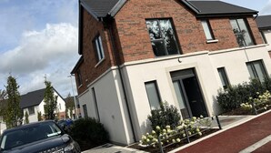 A modern two-story residential building with a brick facade and large windows. - Brand New Luxurious and Modern Family House (Lucan)