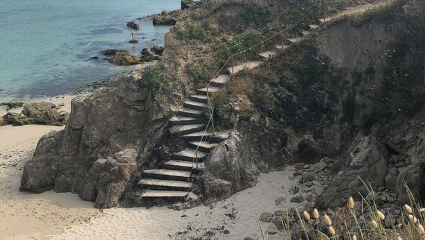 A coastal path with steps leading down to the beach, surrounded by rocky terrain and vegetation. - Maison Refaite et Lumineuse, vue Mer, à 5 Minutes de la Plage (Plogoff)