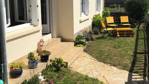 A house with a garden, outdoor seating, and a clear sky. - Maison Refaite et Lumineuse, vue Mer, à 5 Minutes de la Plage (Plogoff)