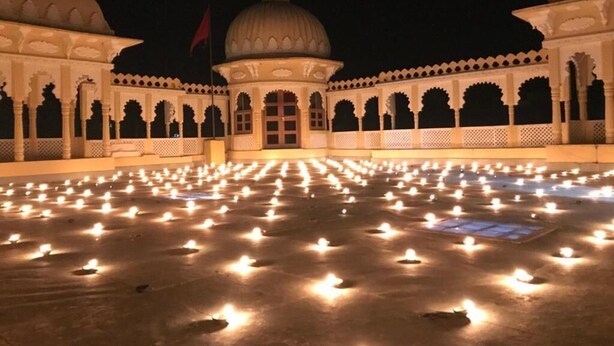 A courtyard with a series of evenly spaced lights, a central dome, and arched walkways. - Deogarh Hills A Village Experience Property (Deogarh Madaria)
