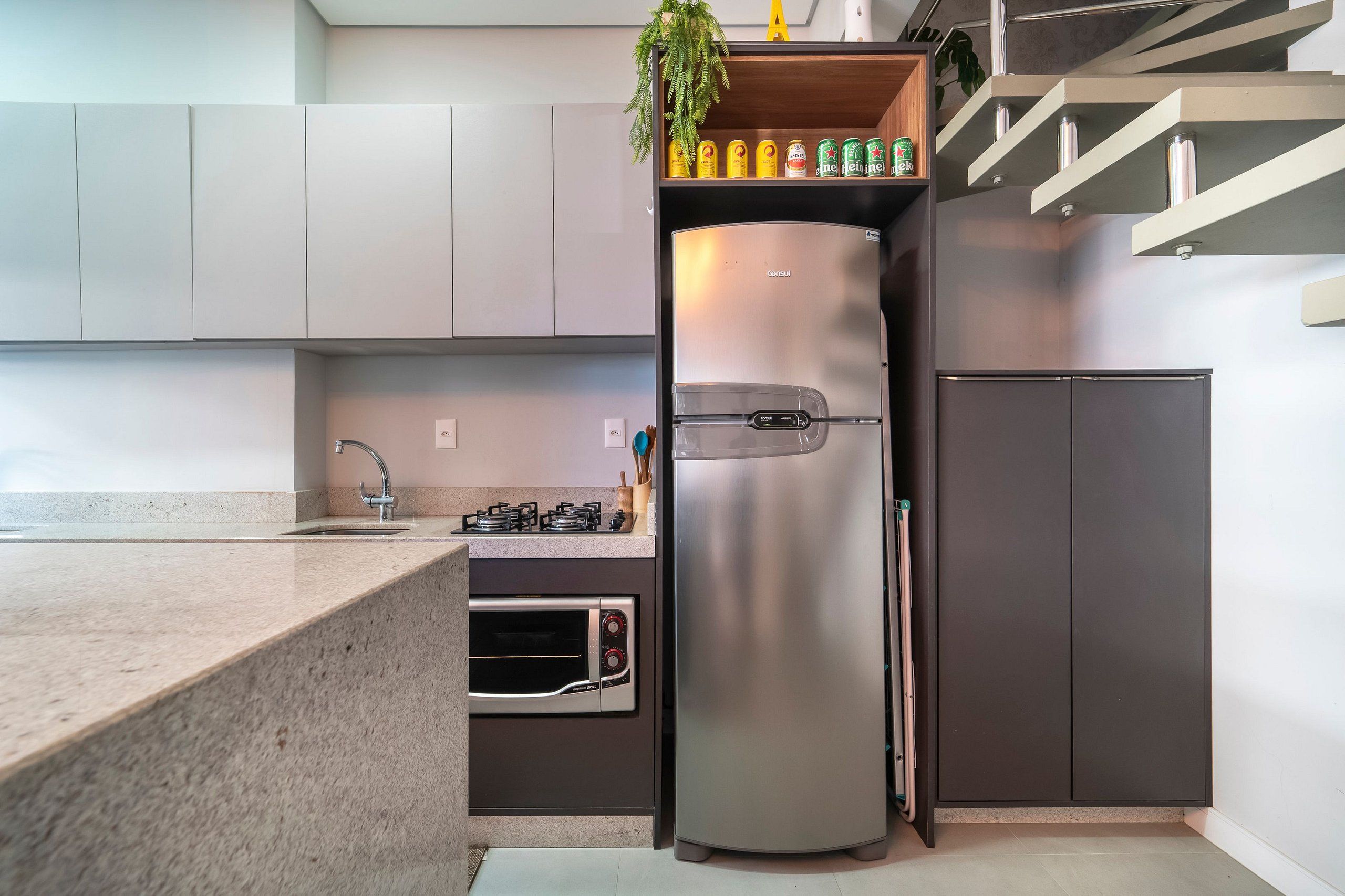 Eine moderne Küche mit Einbauofen, Edelstahlkühlschrank und Gasherd.
