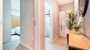 A modern bathroom with a glass shower, a wooden vanity, and a potted plant. - 864C Duplex 80 mts Mar Canto Grande SC (Bombinhas)