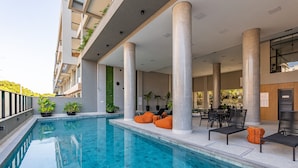 A modern outdoor pool area with seating and potted plants. - 864C Duplex 80 mts Mar Canto Grande SC (Bombinhas)