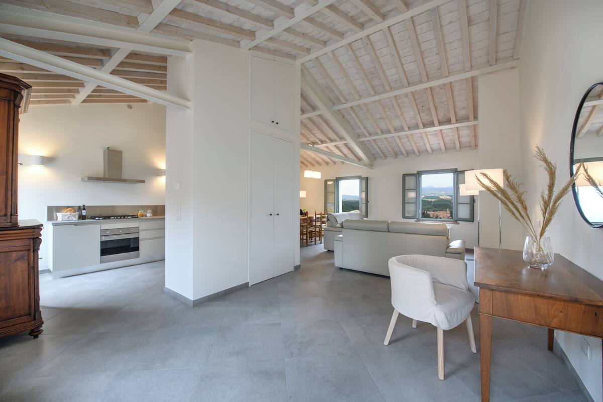 Amplia sala de estar con cocina, comedor y vistas al exterior.