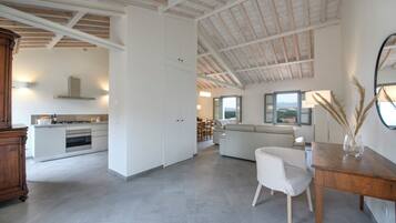 A spacious living area with a kitchen, a dining area, and a view of the outdoors.