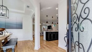 Una cocina moderna con suelo de madera, iluminación colgante y una isla central.