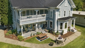 Ein zweistöckiges Haus mit Balkon, Veranda und kleinem Vorgarten.