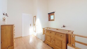 Une pièce avec un meuble en bois, une petite fenêtre et une porte.