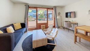Un salon moderne avec un canapé, une table basse et un téléviseur.