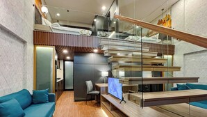 Un interior moderno con un sofá, un televisor y una escalera.