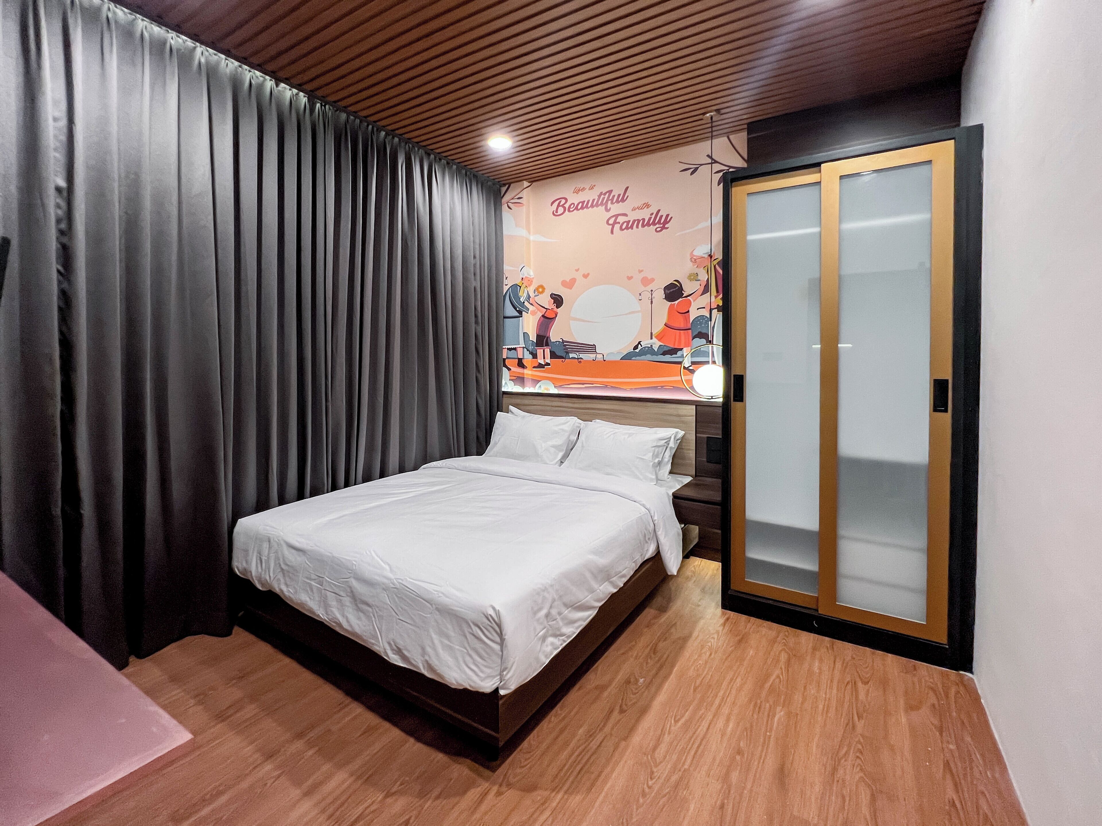 A bedroom with a bed, a wooden ceiling, a sliding glass door, and a wall decoration.