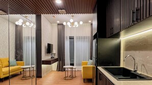 Una cocina moderna con pileta integrada y un comedor con sillas amarillas y una mesa pequeña.