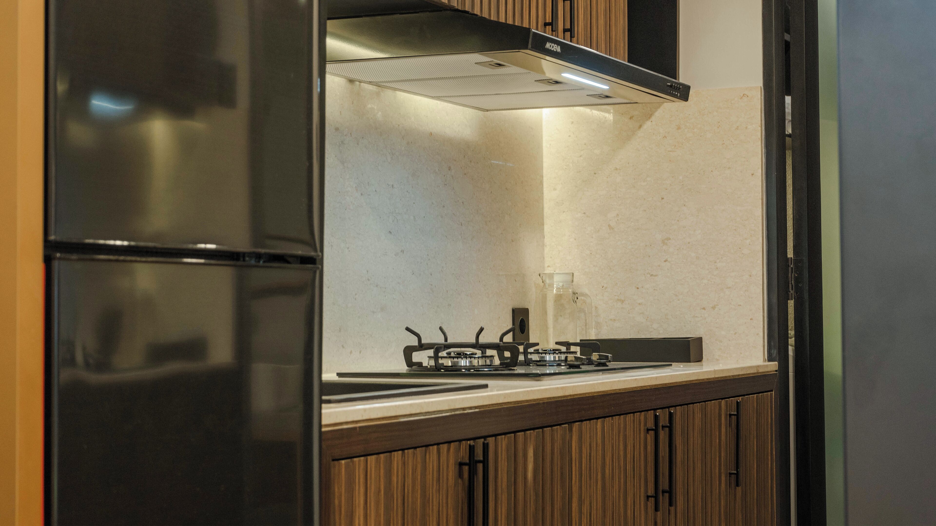 A modern kitchen with a built-in gas stove, stainless steel appliances, and wooden paneling.
