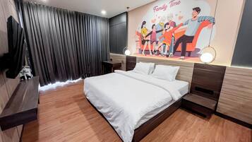 Una habitación de hotel moderna con una cama grande, cortinas oscuras, un mural en la pared que representa a una familia y un televisor sobre un mueble.