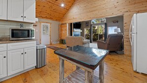 Une cuisine spacieuse avec des meubles en bois, un four à micro-ondes et une table à manger.