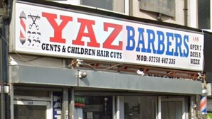 A barbershop with a sign reading "YAZ BARBERS" and "GENTS & CHILDREN HAIR CUTS".