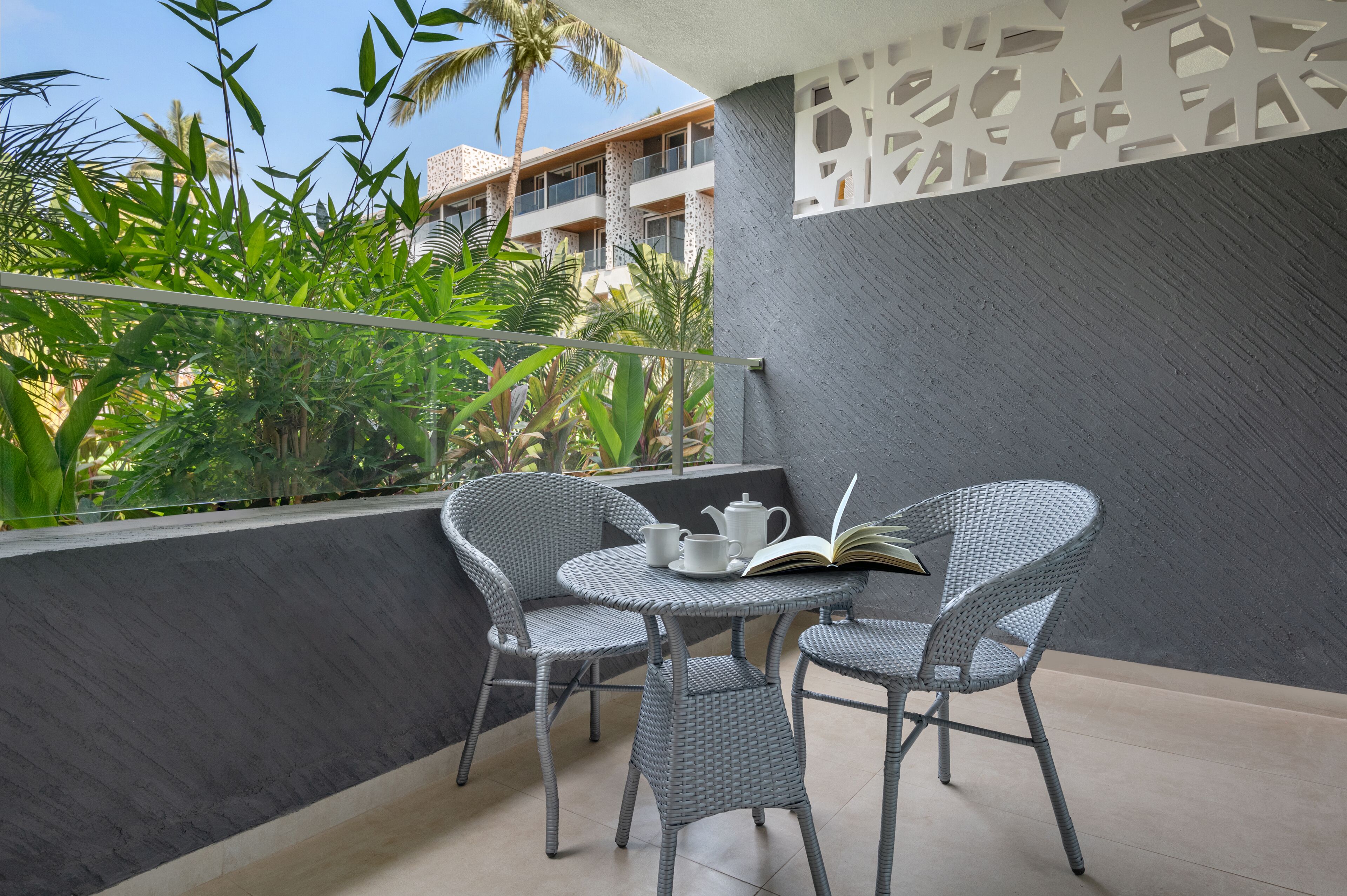 A balcony with wicker chairs, a small round table, and a book.