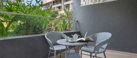 A balcony with wicker chairs, a small round table, and a book.