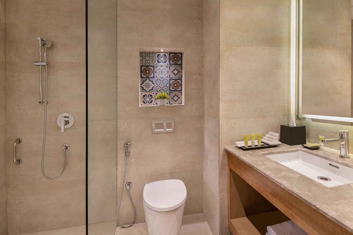 A modern bathroom with a shower, toilet, and sink.